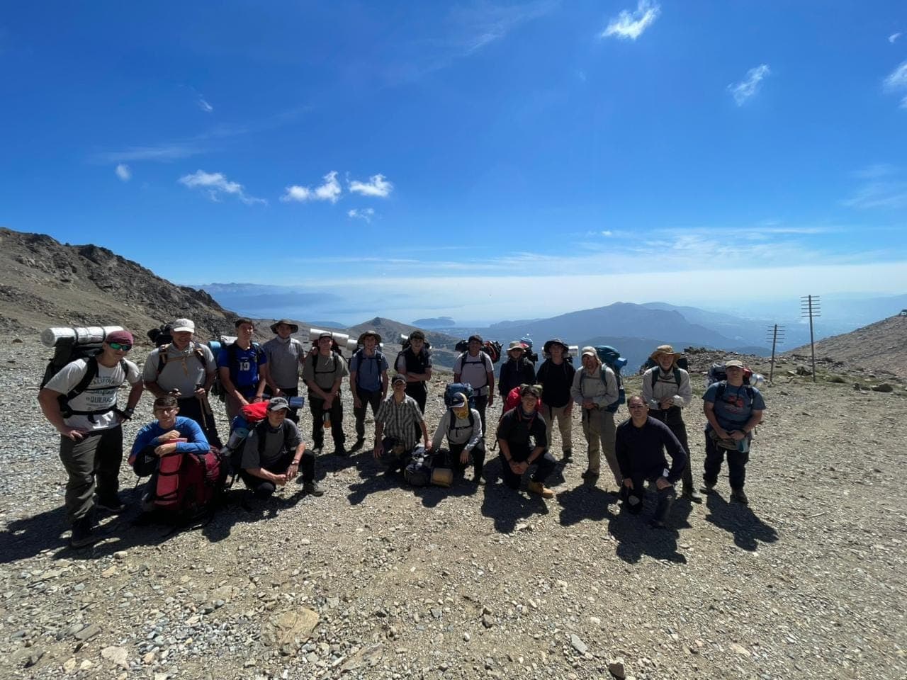 El grupo con las mochilas en un paso de montaña, con el lago y los cerros de fondo